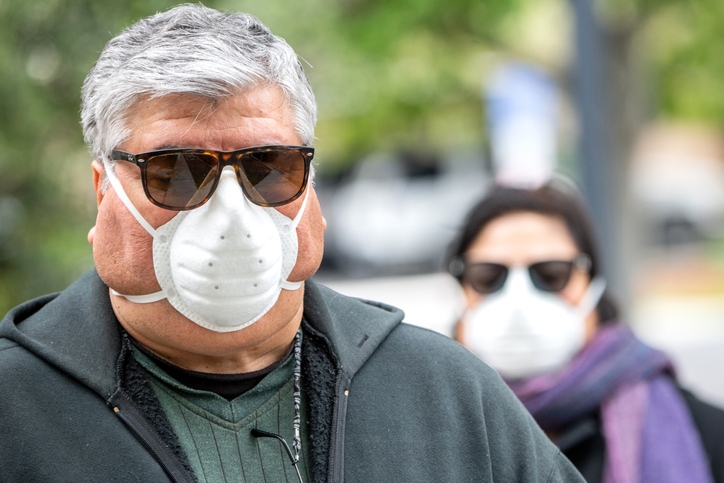 How obesity puts you at risk for severe COVID symptoms - image of two overweight people wearing face masks and sunglasses