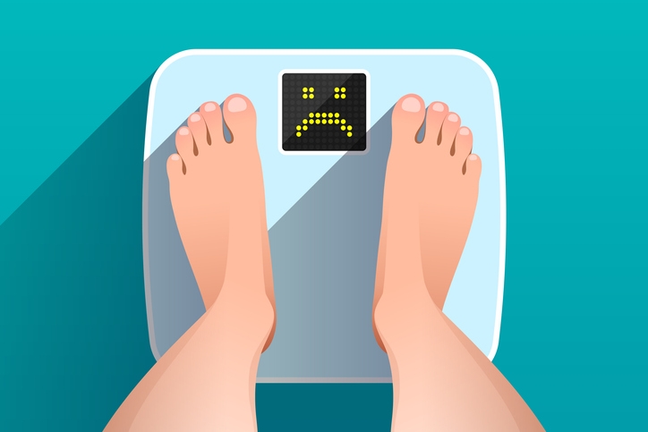 How to break a slow down after a weight loss surgery - feet standing on a scale with a sad face on the scale's screen