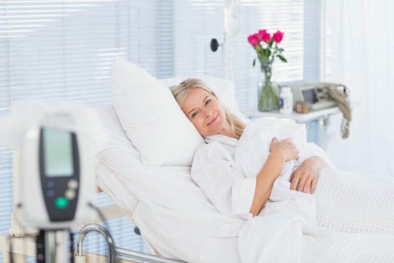 How laproscopic procedures work - content hospital patient smiling in clean and comfy hospital bedding after a procedure